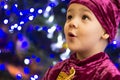 Marmalade bear. Emotional boy three years old in a purple bear costume on the background of a New Year tree and blue lanterns Royalty Free Stock Photo