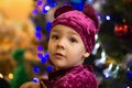 Marmalade bear. Emotional boy three years old in a purple bear costume on the background of a New Year tree and blue lanterns Royalty Free Stock Photo