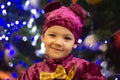 Marmalade bear. Emotional boy three years old in a purple bear costume on the background of a New Year tree and blue lanterns Royalty Free Stock Photo