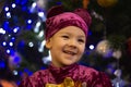 Marmalade bear. Emotional boy three years old in a purple bear costume on the background of a New Year tree and blue lanterns Royalty Free Stock Photo