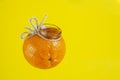 Marmalade jam in a jar with the form of a mandarin orange isolated on yellow Royalty Free Stock Photo