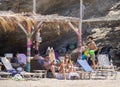 Marmari, Evia island, Greece. August 2020: Holidaymakers and tourists relax on beach loungers and in cafes on the beach on the Gre