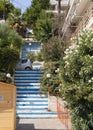 Marmari, Evia island, Greece. August 2020: Stairs up in blue and white among houses and flowers in a Greek resort town on the Aege