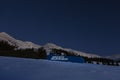 Never Summer snowboard in snowy mountains under bright night stars