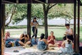 Maroochydore, Australia - February 15, 2020. Females weaving baskets on craft workshop, sitting on carpet in park.