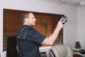 Maroochydore, Australia - March 5, 2020. Young Male Pest Control Worker checking apartment with FLIR E6 thermal imaging