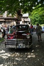 Maroon 1947 Chrysler Windsor Highlander Convertible parked under a tree on a cobblestone road