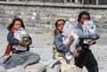 A group of little poor Nepalese children of boys and girls walk along a village street in the Himalayas and carry school books. P