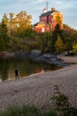 Tourist man photographs Marquette Harbor Lighthouse on the beach Royalty Free Stock Photo