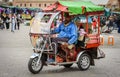 A Moroccan male slowly driving a tuk tuk in Marrakech Jemaa el-Fnaa square Royalty Free Stock Photo