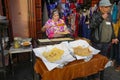 Marrakech, Morocco - Feb 21, 2023: A lady makes fresh flat bread on a market stall in Marrakech Medina