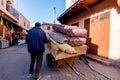 Old muslim man with cart selling carpets at traditional street market in Morocco. Royalty Free Stock Photo