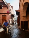 Marrakech, Morocco, 24.10.2021. Moroccan couple riding motorbike in Medina. Ray of sun in narrow alleyway.