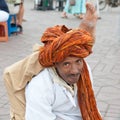 Marrakech: Street Artist on Djemaa el Fna with turban on head and leg behind neck, Marrakech, Morocco