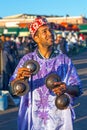 Moroccan musician in traditional costume playing with a pair of Krakebs