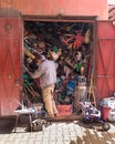 Marrakesh, Morocco - March 14, 2018: A man rummages through all the objects in a completely full storage room in the medina of