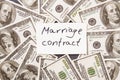 Marriage contract and dollars pile.