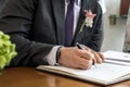 Marriage elegant groom signing german wedding register holding pen and official document couple Royalty Free Stock Photo