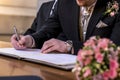 Marriage elegant groom signing german wedding register holding pen and official document couple Royalty Free Stock Photo