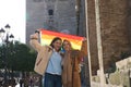 Marriage of lesbians on holiday and tourism in sevilla. They are in front of the cathedral and hold the gay pride flag in their