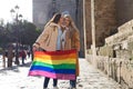 Marriage of lesbians on holiday and tourism in seville. They are in front of the cathedral and they are holding the gay pride flag