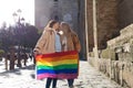 Marriage of lesbians on holiday and tourism in seville. They are in front of the cathedral and they are holding the gay pride flag
