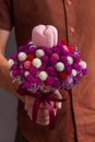 Marriage proposal. Elegant man in brown shirt gives white gold ring in pink box on beautiful flowers bouquet, engagement Royalty Free Stock Photo