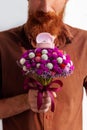 Marriage proposal. Handsome elegant man in brown shirt gives a white gold ring in pink box on beautiful flowers bouquet Royalty Free Stock Photo