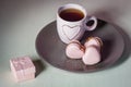 A marriage proposal. Will you marry me? Pink heart macarons with light pink tea cup on the plate and cream background. Royalty Free Stock Photo