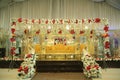 Marriage stage red and white flowers with golden sofa