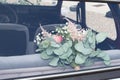 Marriage wedding flower bouquet in rear window bride car Royalty Free Stock Photo