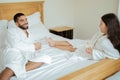 Married Couple Drinking Champagne Lying In Bed In Hotel Suite Royalty Free Stock Photo