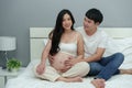 Married couple is expecting baby. man embraces his pregnant wife on bed Royalty Free Stock Photo