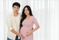 Married couple is expecting baby. man embraces his pregnant wife on window background Royalty Free Stock Photo