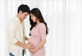 Married couple is expecting baby. man embraces his pregnant wife on window background Royalty Free Stock Photo