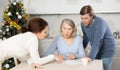 Married couple helps elderly mother write testament in kitchen at christmas Royalty Free Stock Photo