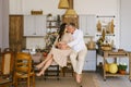 Married couple hugs while sitting on a table in the kitchen. The husband hugs his pregnant wife, putting his hands on her big Royalty Free Stock Photo