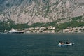 A married couple is kayaking, amicably rowing oars along Kotor Bay in Montenegro, against the background of the city of
