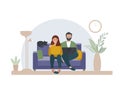 A married couple with a laptop sits at home on the sofa. Work at home, online education. Students or freelancers, bloggers