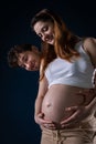 A married couple looks at the pregnancy belly with interest and they are happy because soon I will have a child. Hands Royalty Free Stock Photo