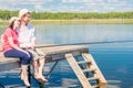 A married couple on a pier with bare feet catching a fish