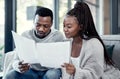 Married couple planning their finance and budget bills or papers together at home. Serious husband and young wife