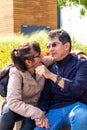 Married couple seated and holding hands