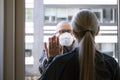 A married couple separated by Corona Covid-19 virus. She is quarantined indoors and he is outside wearing protective mask. They ar Royalty Free Stock Photo