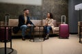 Married couple with suitcases, partners on a business trip discussing plans and projects in a VIP lounge meeting room while Royalty Free Stock Photo