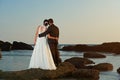 Married couple watching sunset on ocean beach Royalty Free Stock Photo