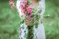 A married woman holds out a bouquet of wild flowers to the camera. The hand of a woman with an engagement ring holds lilac Royalty Free Stock Photo