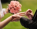 Marry me. Groom put a ring on finger of his lovely wife.