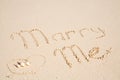 Marry me written on sand