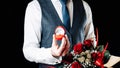 Marry me. Young happy man holding red gift box with diamond engagement ring, red roses bouquet. Engagement marriage ring Royalty Free Stock Photo